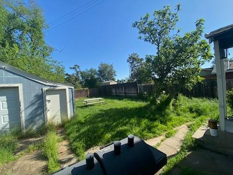 view of yard with an outbuilding and fence
