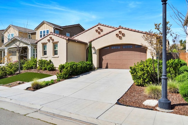 mediterranean / spanish-style home featuring a tile roof, an attached garage, driveway, and stucco siding