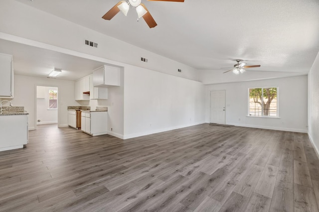 2464 S Kirk St, Fresno, CA 93706 - unfurnished living room with a ceiling fan, healthy amount of natural light, and wood finished floors