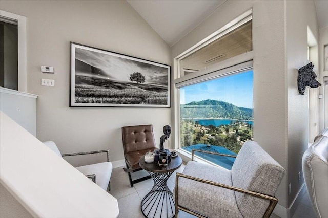 sitting room featuring tile patterned floors, a mountain view, baseboards, and vaulted ceiling