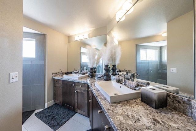 full bath with tile patterned floors, plenty of natural light, and a sink
