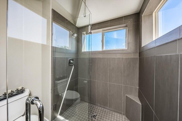 bathroom featuring tile patterned floors, toilet, and a shower stall