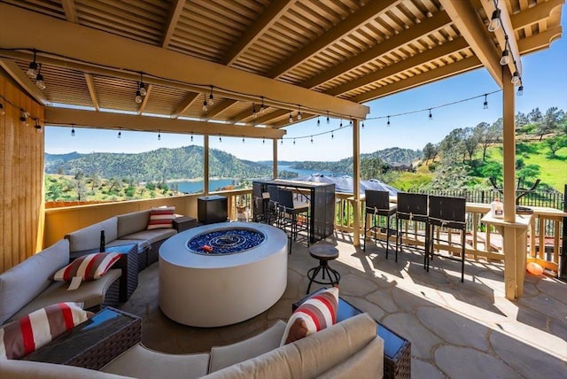 view of patio / terrace featuring a mountain view and an outdoor living space with a fire pit