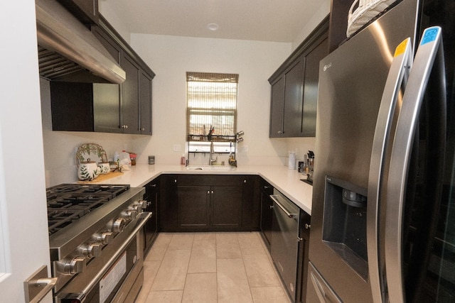 kitchen featuring range hood, a sink, light countertops, stainless steel appliances, and light tile patterned flooring