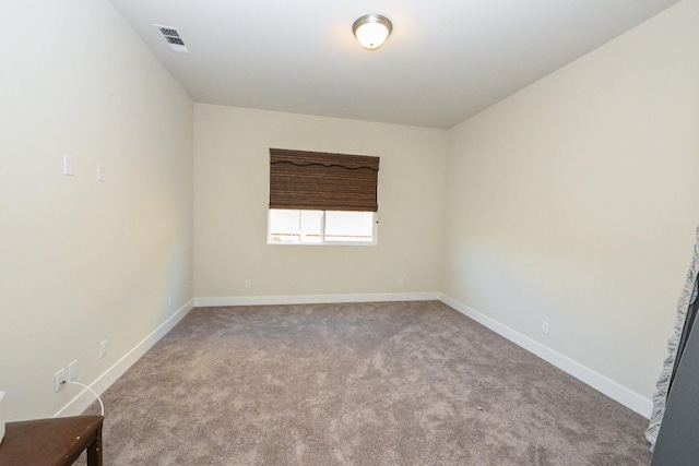 carpeted spare room with baseboards and visible vents