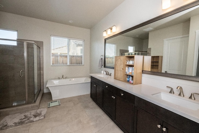 bathroom featuring a shower stall, a freestanding tub, double vanity, and a sink