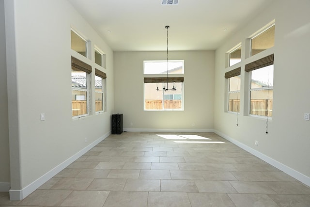 unfurnished dining area featuring a notable chandelier, baseboards, and visible vents