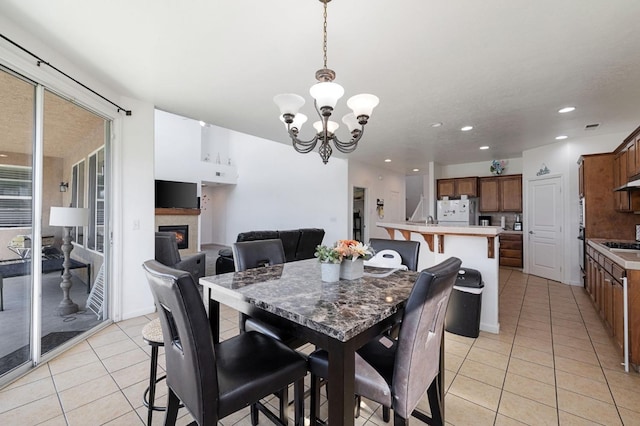 2594 S Duke Ave, Fresno, CA 93727 - dining space featuring light tile patterned floors, recessed lighting, an inviting chandelier, and a glass covered fireplace