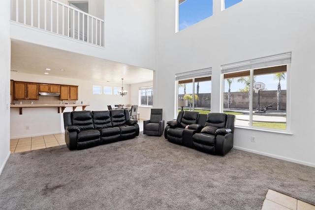 2594 S Duke Ave, Fresno, CA 93727 - living room featuring a notable chandelier, a towering ceiling, baseboards, light tile patterned floors, and light colored carpet