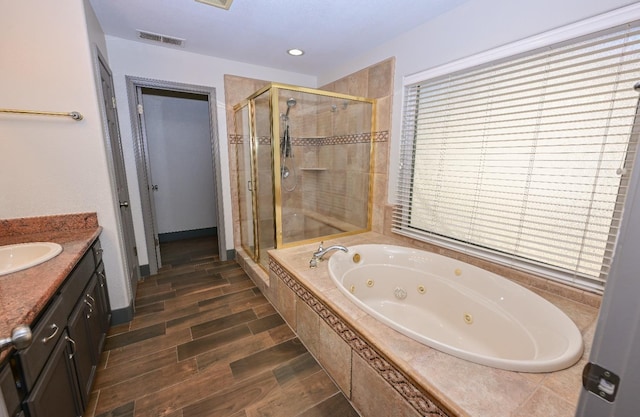 738 Century Ln, Clovis, CA 93612 - bathroom featuring a shower stall, vanity, visible vents, wood finished floors, and a jetted tub