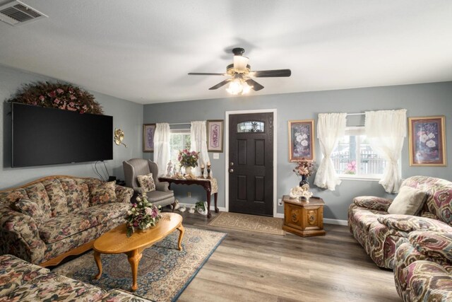 607 N 4th St, Fresno, CA 93702 - living room featuring visible vents, a ceiling fan, baseboards, and light wood-type flooring