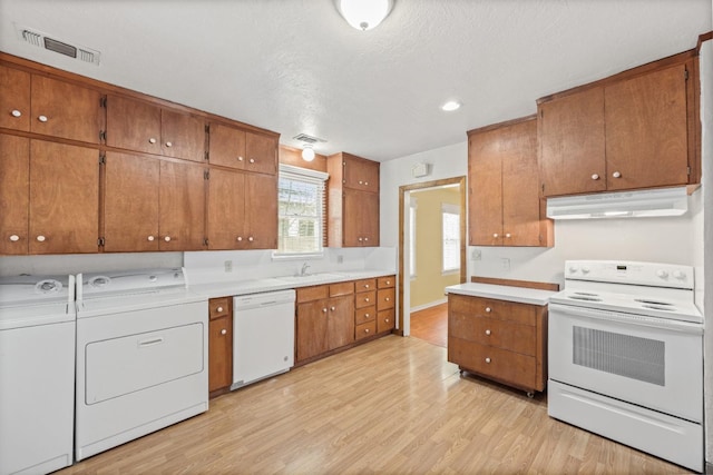 811 E Cambridge Ave, Fresno, CA 93704 - kitchen with white appliances, under cabinet range hood, separate washer and dryer, a sink, and light wood finished floors