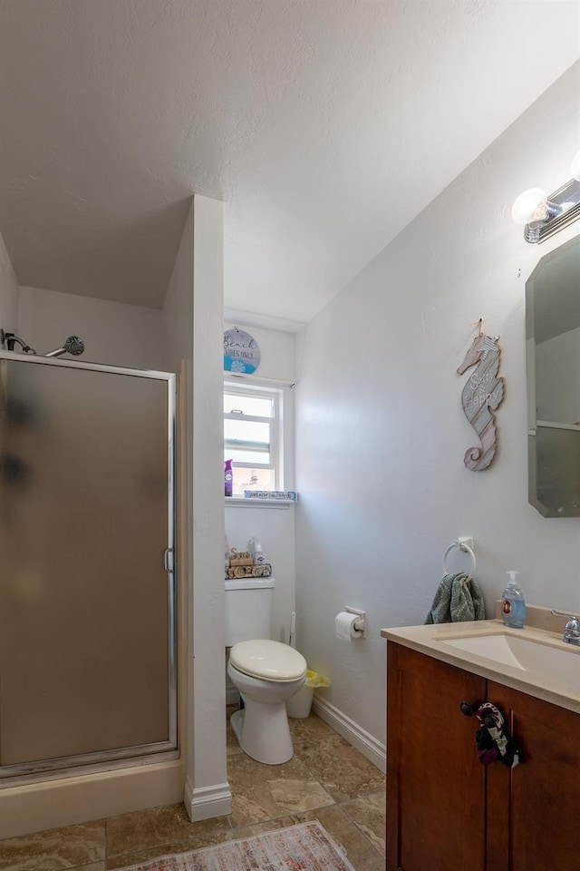 full bathroom featuring toilet, baseboards, a shower stall, and vanity