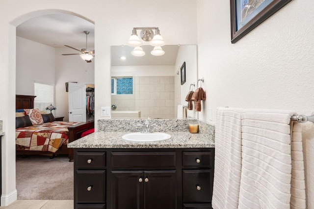 ensuite bathroom with ensuite bathroom, a ceiling fan, and vanity