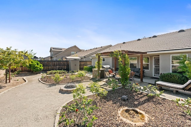 back of property featuring an outdoor fire pit, a patio, a fenced backyard, and a tile roof