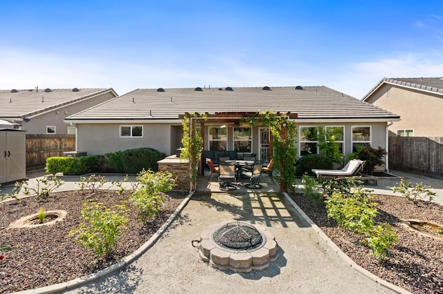 back of property with a patio, a fire pit, a tiled roof, and fence