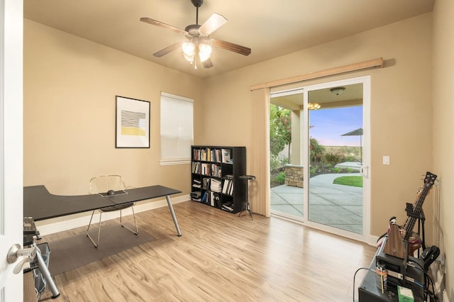 office space featuring baseboards, ceiling fan, and wood finished floors