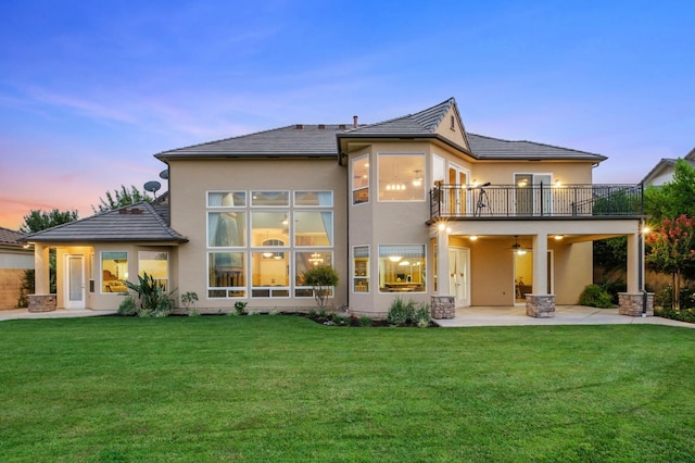 rear view of property featuring a patio, ceiling fan, a balcony, and stucco siding