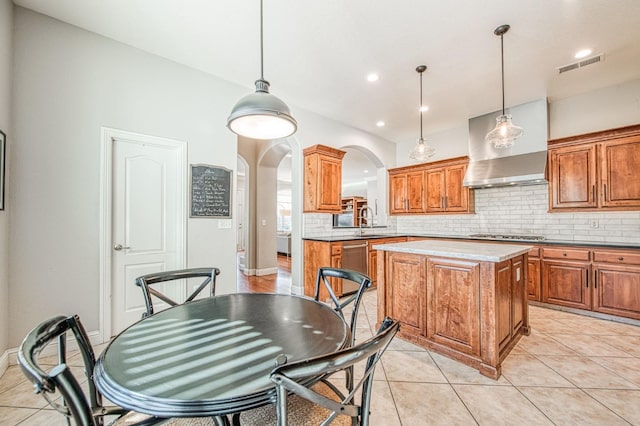 8389 N Paula Ave, Fresno, CA 93720 - kitchen with tasteful backsplash, visible vents, arched walkways, and brown cabinets