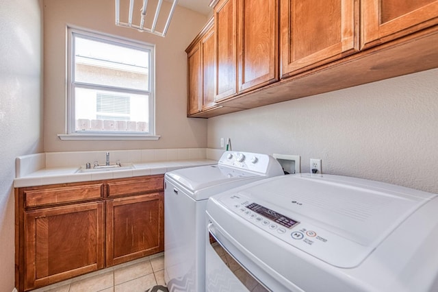 8389 N Paula Ave, Fresno, CA 93720 - laundry area featuring light tile patterned flooring, washing machine and dryer, a sink, and cabinet space