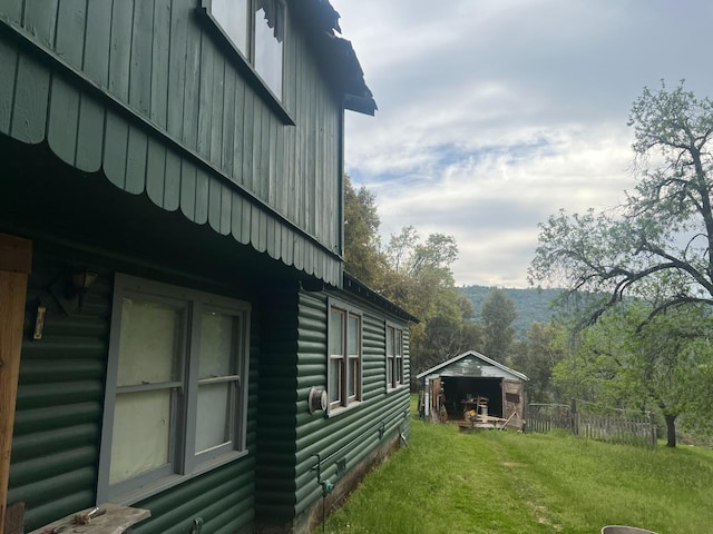 50364 Rd 426, Oakhurst, CA 93644 - view of side of home featuring faux log siding, a yard, board and batten siding, fence, and an outdoor structure