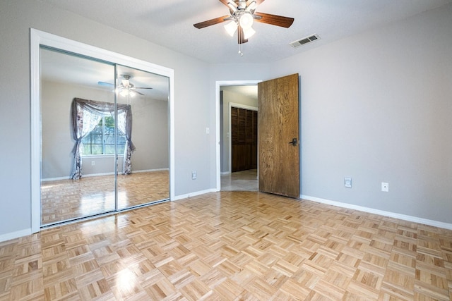 unfurnished bedroom featuring a closet, visible vents, baseboards, and ceiling fan