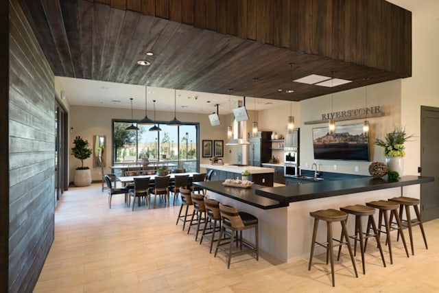 bar featuring a sink, pendant lighting, wood ceiling, and oven