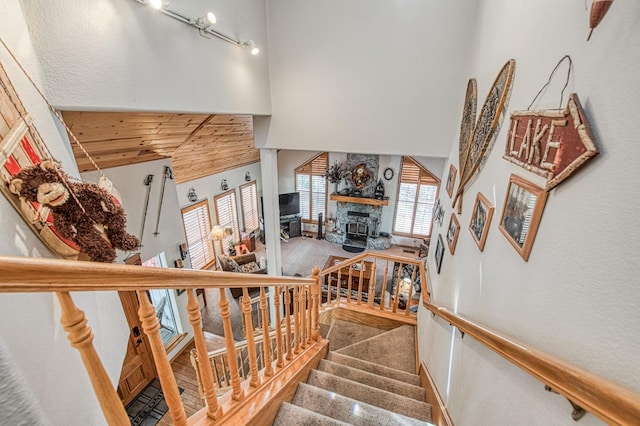 41811 Gray Rock Rd, Shaver Lake, CA 93664 - staircase with wooden ceiling, carpet flooring, a high ceiling, and a fireplace