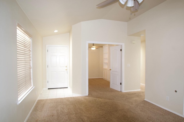 spare room featuring lofted ceiling, light colored carpet, and ceiling fan