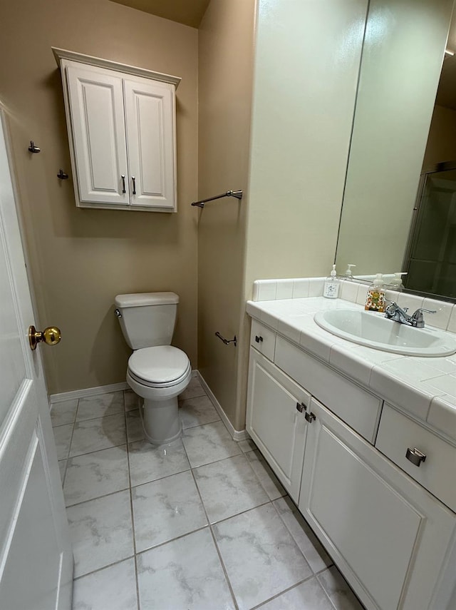 bathroom featuring marble finish floor, toilet, vanity, and baseboards