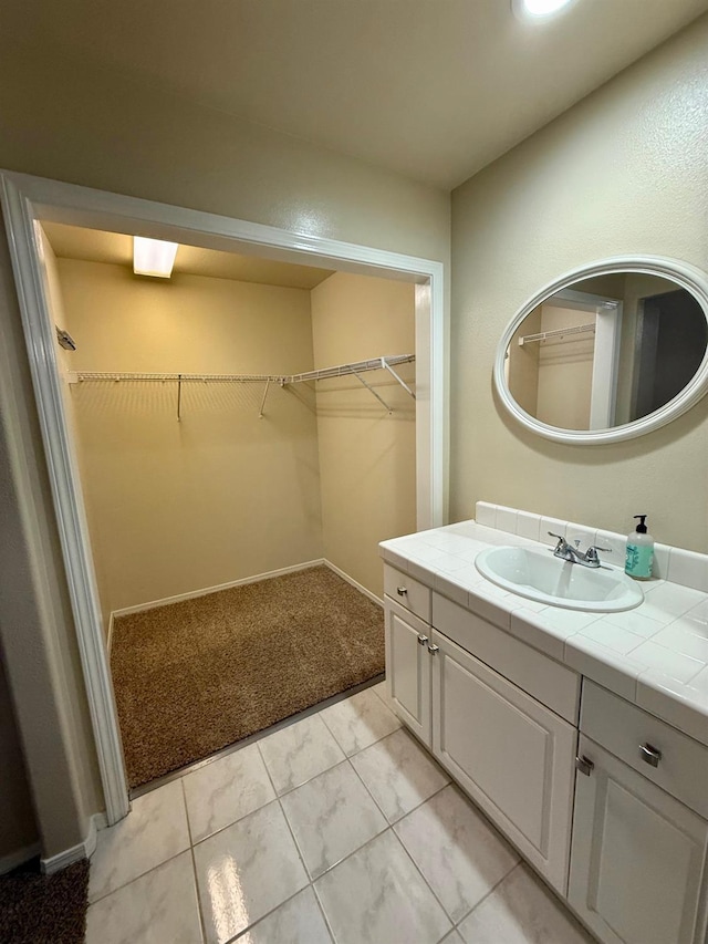 bathroom featuring a walk in closet and vanity