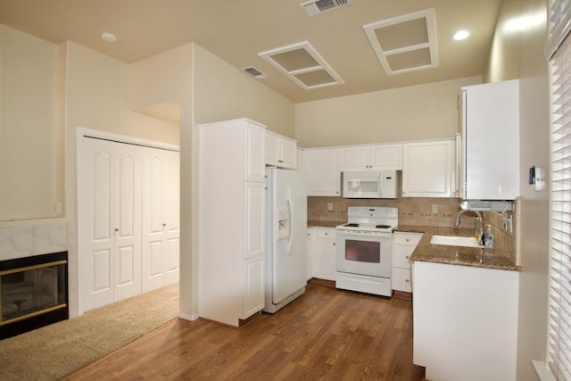 kitchen with dark wood-style flooring, a sink, white appliances, and visible vents