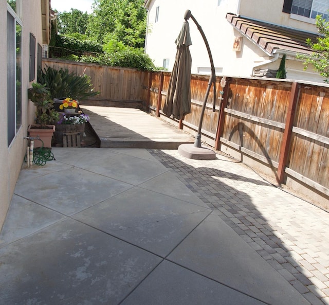 view of patio featuring a wooden deck and a fenced backyard