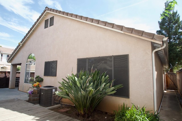 rear view of house featuring fence, a patio area, cooling unit, and stucco siding