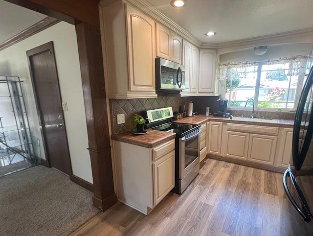 1450 W Chennault Ave, Fresno, CA 93711 - kitchen with a sink, decorative backsplash, appliances with stainless steel finishes, light wood finished floors, and ornamental molding