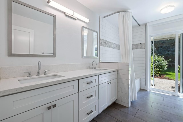 full bathroom with double vanity, a sink, and tile patterned floors
