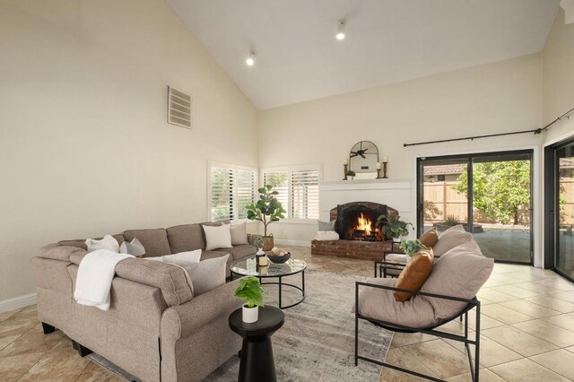 10001 N Pheasant Run Dr, Fresno, CA 93730 - living area featuring high vaulted ceiling, a fireplace, light tile patterned floors, and plenty of natural light