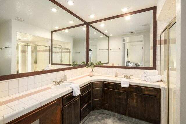 10001 N Pheasant Run Dr, Fresno, CA 93730 - full bath with tasteful backsplash, a shower stall, double vanity, and recessed lighting
