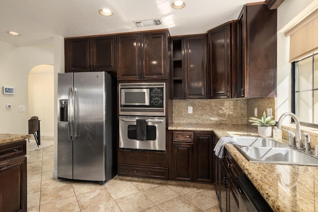 10001 N Pheasant Run Dr, Fresno, CA 93730 - kitchen with appliances with stainless steel finishes, arched walkways, tasteful backsplash, recessed lighting, and a sink