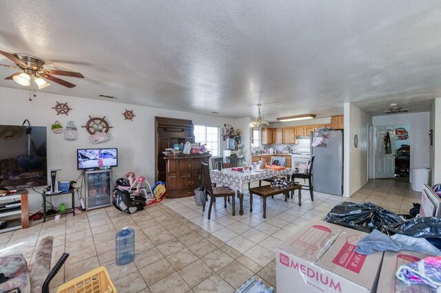 dining space featuring light tile patterned flooring, a textured ceiling, visible vents, and ceiling fan