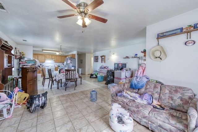 living room featuring light tile patterned flooring, visible vents, and ceiling fan