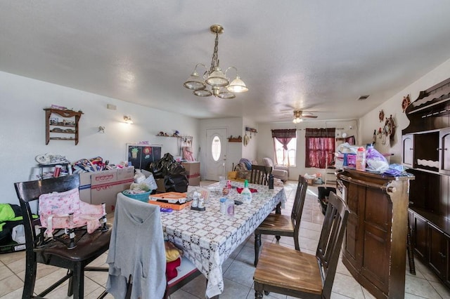 dining area featuring light tile patterned flooring, visible vents, and ceiling fan with notable chandelier