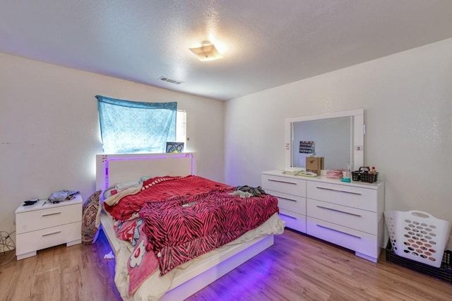bedroom featuring light wood-type flooring and visible vents