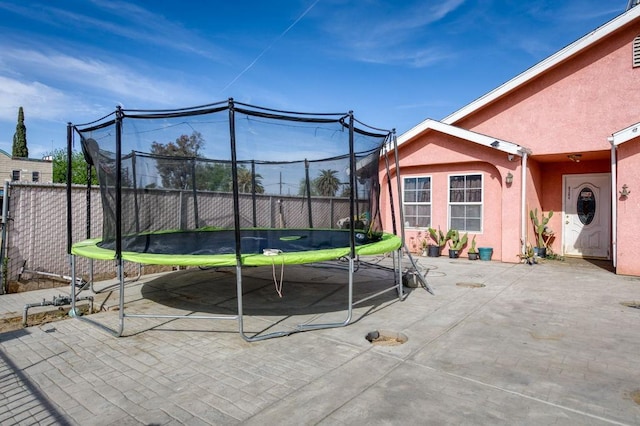 view of patio with a trampoline and a fenced backyard