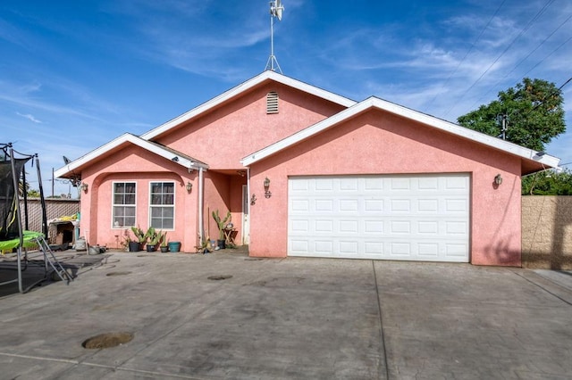 single story home featuring stucco siding, driveway, and a garage