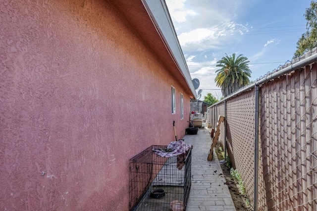 view of home's exterior with fence and stucco siding
