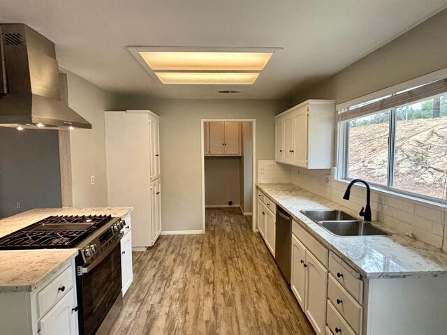 28813 Limestone Cir, Coarsegold, CA 93614 - kitchen with stainless steel appliances, a sink, wall chimney exhaust hood, light wood finished floors, and white cabinets