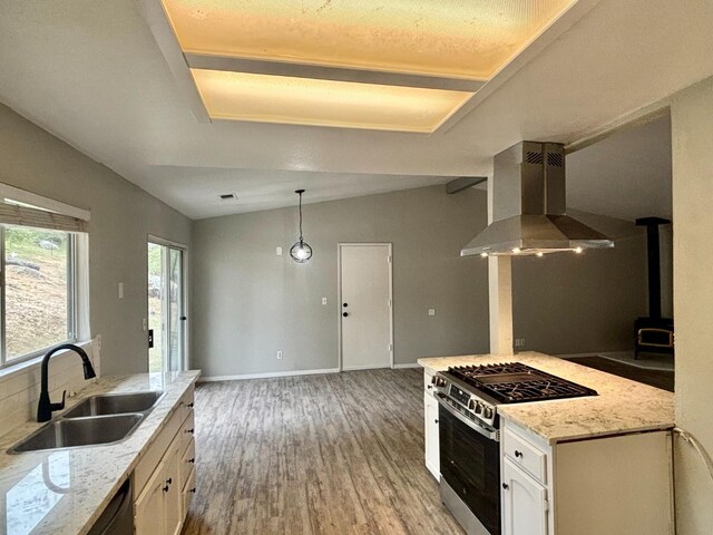 28813 Limestone Cir, Coarsegold, CA 93614 - kitchen with stainless steel range with gas cooktop, wall chimney exhaust hood, a sink, light wood finished floors, and white cabinets