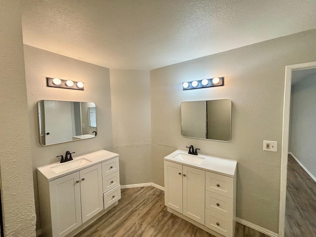 28813 Limestone Cir, Coarsegold, CA 93614 - full bathroom featuring wood finished floors, baseboards, two vanities, and a textured ceiling