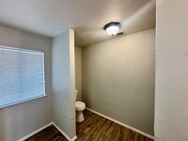 28813 Limestone Cir, Coarsegold, CA 93614 - bathroom featuring wood finished floors, toilet, baseboards, and a textured ceiling